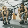 A man and a woman are in a gym, both holding slam balls. Náhľad obrázku produktu