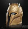 A close-up studio shot of a golden helmet with silver spikes against a black background. Anteprima dell’immagine prodotto