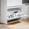 A white shoe cabinet with two flip-out drawers, displaying shoes inside. Anteprima dell’immagine prodotto