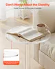 A clear acrylic side table with a book and a cup of coffee on it, placed next to a cream-colored sofa. Podgląd zdjęcia produktu