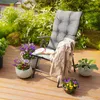 A chair cushion on a wooden deck with plants and a book. Anteprima dell’immagine prodotto