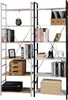 Two tall, narrow bookshelves are shown side-by-side, filled with books, decorative items, and storage boxes. The left bookshelf has a lighter wood tone and white metal frame, while the right has a darker wood tone and black metal frame. Produktbild-Vorschau