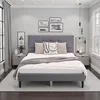 A bedroom scene featuring a gray upholstered bed. Voir les images du produit