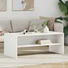 A white coffee table in a living room setting with a sofa and plant. Podgląd zdjęcia produktu
