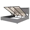 A grey upholstered bed frame with the mattress support mechanism open, revealing the storage space underneath. Produktbild-Vorschau