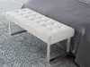 A white tufted bench in front of a bed on a patterned tile floor. Produktbild-Vorschau