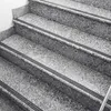 A close-up view of granite stairs with black anti-slip strips. Produktbild-Vorschau