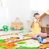 A young girl is playing on a colorful play mat with animal designs in a child's room. Produktbild-Vorschau