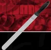 A cake knife with a black handle and a long silver blade is shown diagonally against a blurred red background with abstract wavy lines and a black foreground. Anteprima dell’immagine prodotto
