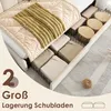 A bed with storage drawers pulled out, showing folded linens and storage boxes. Anteprima dell’immagine prodotto