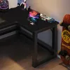 A black L-shaped gaming desk with a tablet, a toy car, and a skateboard on it. Produktbild-Vorschau