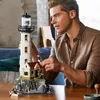A man is building a LEGO lighthouse model on a table. Produktbild-Vorschau
