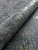 A close-up of a roll of wallpaper with a concrete and gold metallic design. Produktbild-Vorschau