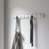 A white wall-mounted coat rack with two items hanging on it. Podgląd zdjęcia produktu