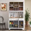 A white sideboard with wood accents, filled with various items like bottles, glasses, mugs, and decorative objects, set against a neutral wall. Produktbild-Vorschau