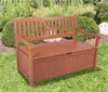 A wooden storage bench is placed outdoors in a garden setting with greenery and rocks in the background. Produktbild-Vorschau