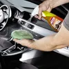 A person is cleaning the interior of a car, spraying a cleaning product onto a microfiber cloth and then onto the dashboard. Produktbild-Vorschau
