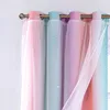 Close-up of colorful ombre curtains with star details hanging from a curtain rod. Voir les images du produit
