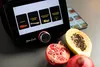 A kitchen appliance with a touchscreen interface, next to fresh fruit. Produktbild-Vorschau
