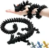 A hand holding a black 3D printed dragon toy, with another part of the dragon's body wrapped around the arm. Produktbild-Vorschau