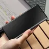 A hand holding a black smartphone with a privacy screen protector. Anteprima dell’immagine prodotto