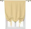 A beige tie-up Roman shade curtain is shown hanging over a white-framed window. Voir les images du produit