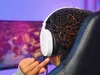 A person wearing white headphones is looking at a computer screen. Anteprima dell’immagine prodotto