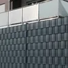 A close-up view of a dark gray privacy screen fence, with a balcony railing visible in the background. Produktbild-Vorschau