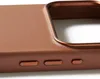 A close-up view of the side of a brown leather phone case, showing the textured material and metallic buttons. Voir les images du produit
