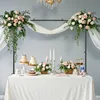 A table decorated for a celebration with cakes, flowers, and candles. Voir les images du produit