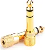 Two gold-colored audio adapters are shown against a white background. Podgląd zdjęcia produktu
