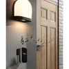 A wireless doorbell system is shown mounted on a wall next to a wooden door, with musical notes indicating sound. Náhľad obrázku produktu