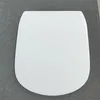 A white toilet seat lid is shown from a top-down perspective on a gray textured surface. Náhled obrázku produktu