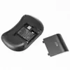 The back of a black wireless keyboard with the battery compartment open, showing the battery and the battery cover next to it. Voir les images du produit