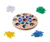 A circular wooden game board with card slots and colored chips scattered around it. Produktbild-Vorschau