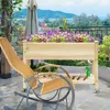 A raised garden bed filled with flowers sits on a patio next to a rocking chair, with a view of water and hills in the background. Produktbild-Vorschau