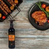 A bottle of Lea & Perrins Worcestershire sauce is placed on a wooden table next to a grilled steak and skewers of meat. Podgląd zdjęcia produktu