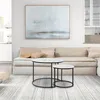 A living room scene with a sofa, coffee tables, and artwork. Produktbild-Vorschau