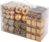 A clear, well-lit studio shot of a set of champagne-colored Christmas ornaments in a transparent plastic box. Náhled obrázku produktu