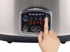A close-up of a slow cooker's control panel with a finger pressing a button. Anteprima dell’immagine prodotto