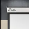 A close-up view of the top part of a retractable projector screen, showing the brand logo and mounting hardware. Produktbild-Vorschau