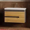A bathroom vanity with a ceramic sink and faucet mounted on a marble-tiled wall. Produktbild-Vorschau