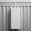 A white ceramic humidifier hangs from a hook on a radiator. Produktbild-Vorschau