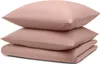 A stack of folded bedding in a light pink color. Voir les images du produit