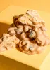 A pile of cookie caramel clusters on a yellow surface. Produktbild-Vorschau