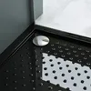 A close-up view of a black shower tray with a silver drain cover. Produktbild-Vorschau