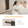 A woman and a baby in a bathroom with a radiator. Produktbild-Vorschau