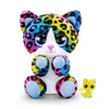 A plush toy cat with rainbow-colored fur and large, sparkly eyes sits next to a small, yellow plastic cat figurine against a white background. Podgląd zdjęcia produktu