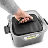 A hand is shown holding a black fabric bag with a handle, which is placed inside a gray plastic container. Produktbild-Vorschau