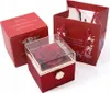 A red gift box containing a preserved red rose, next to a red gift bag and another red box. Anteprima dell’immagine prodotto